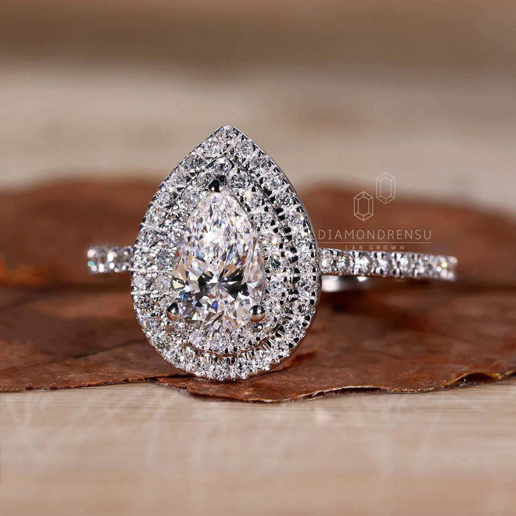 Pear shape diamond ring with pave diamond ring details and an exquisite white gold finish.