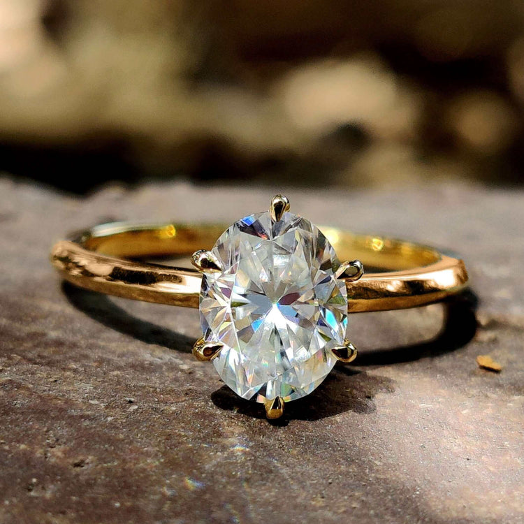 Oval solitaire engagement ring on hand