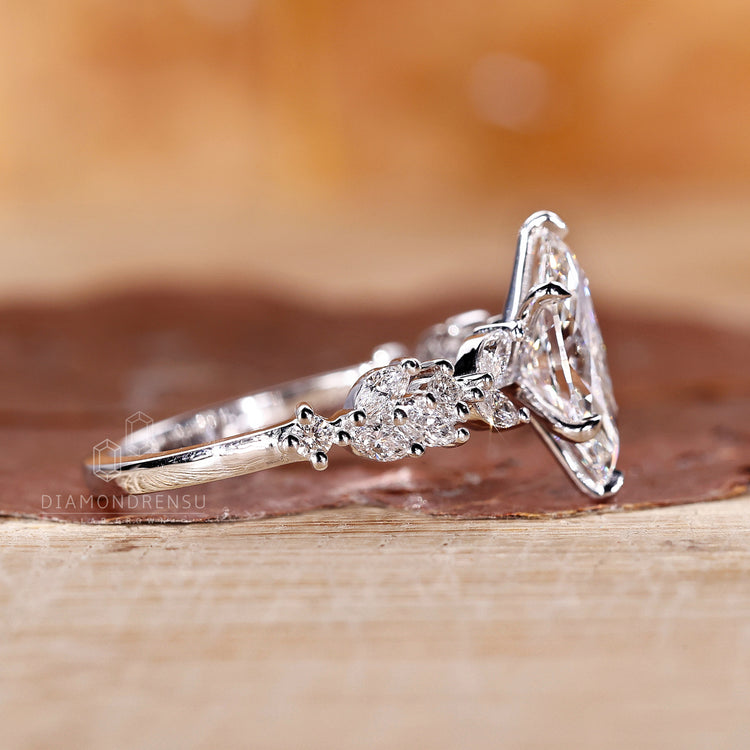 Proposal engagement ring with marquise and round diamond pave band.