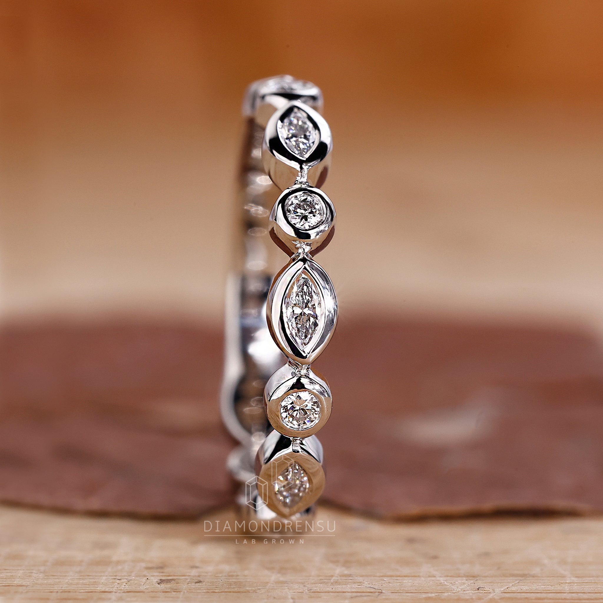 Buy wedding band with bezel setting and mixed diamond shapes.