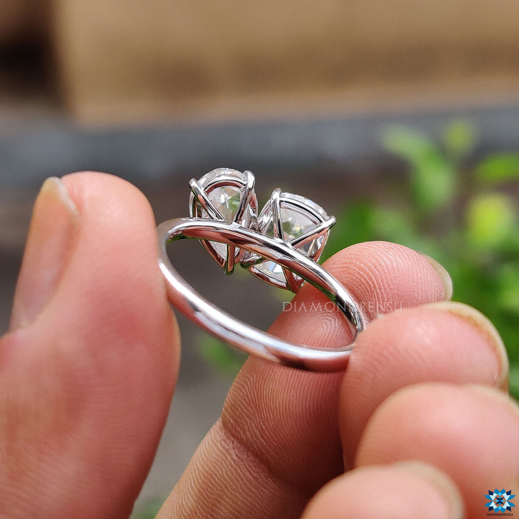Prong setting moissanite ring with two stone design.