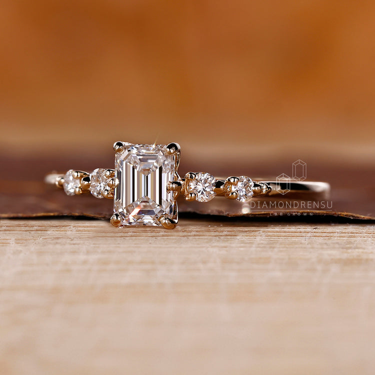 Emerald cut diamond center stone in yellow gold.