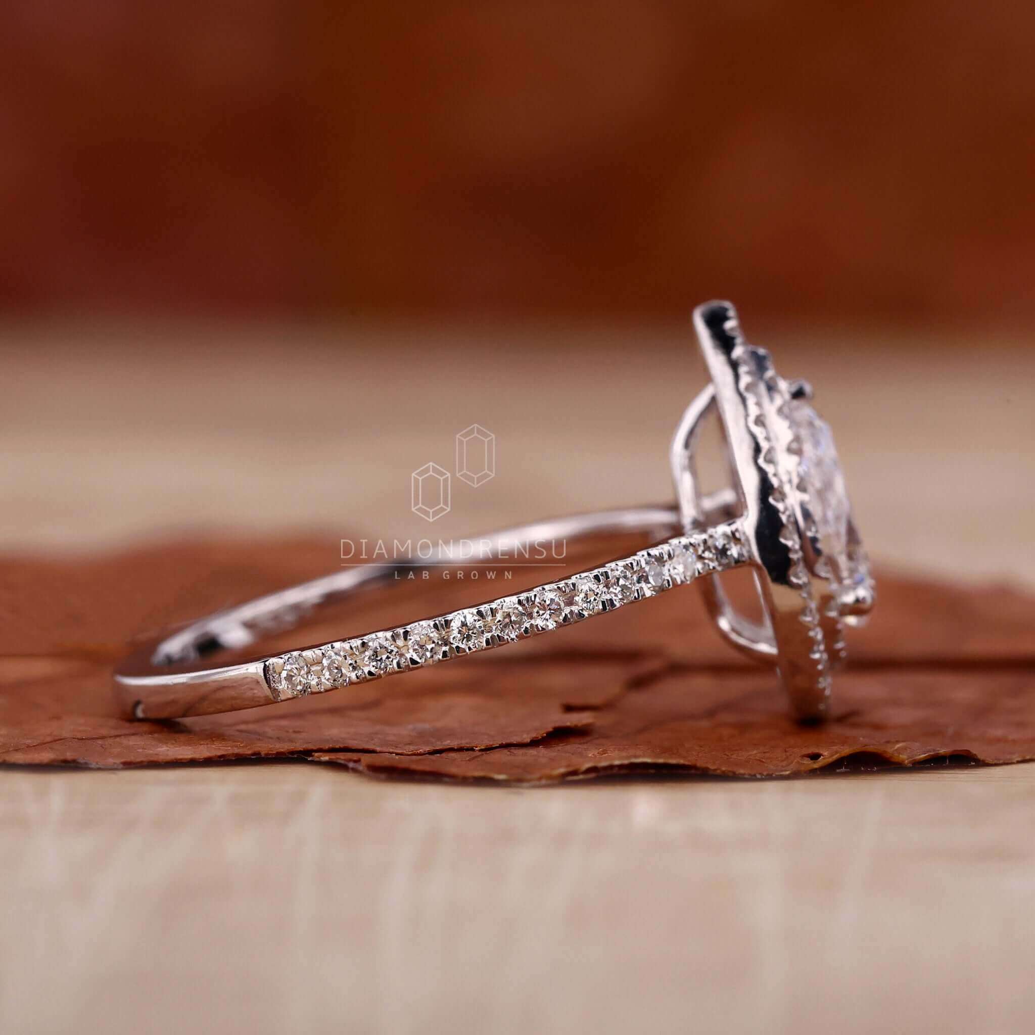 Pear shaped ring diamond set in a white gold engagement ring with pave accents.