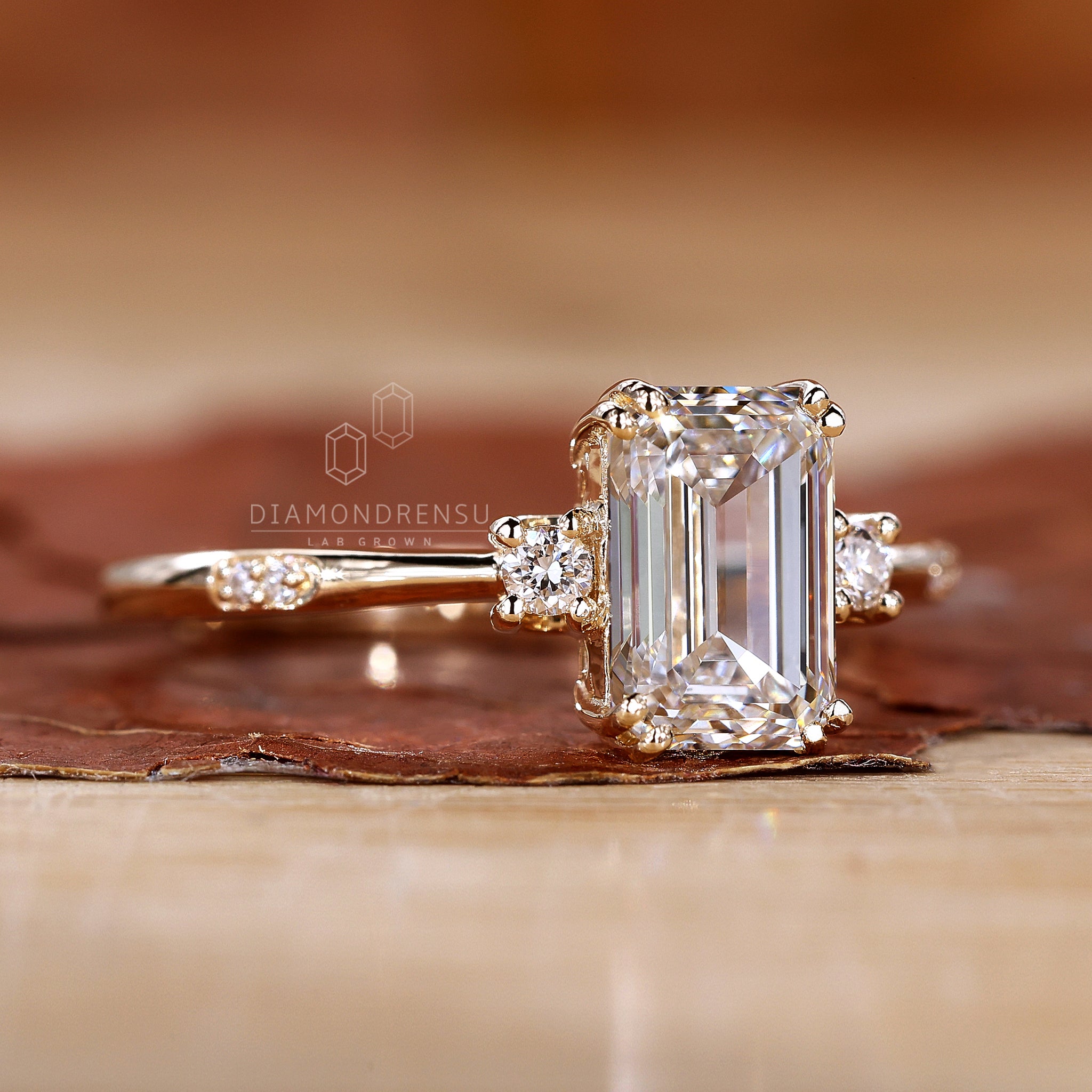 Classic three stone engagement ring with a sparkling emerald cut centre stone.