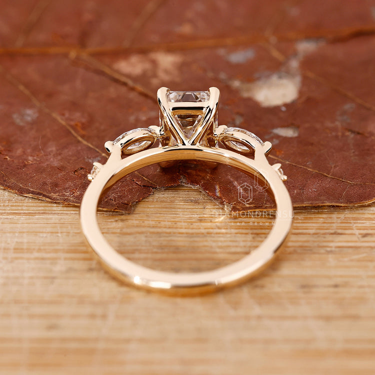 Lab diamond ring featuring emerald center and 2 marquise, 2 round side stones.