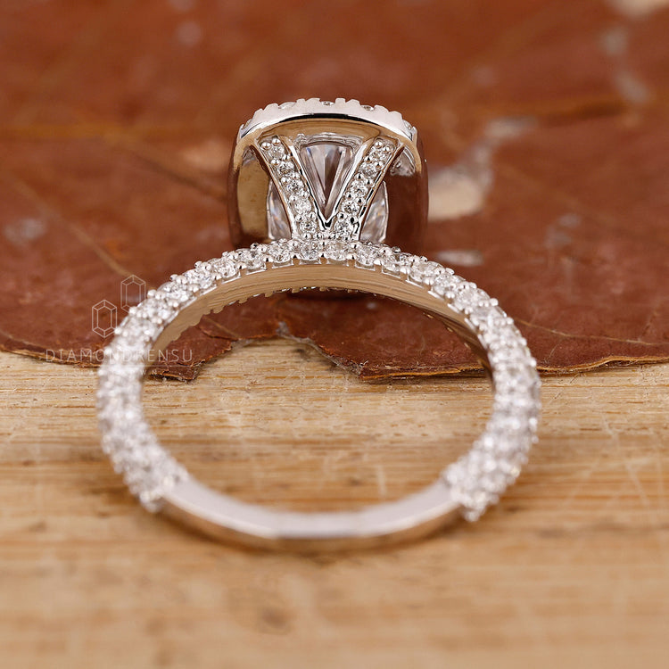 White gold ring with prong set oval diamond and pave set band.