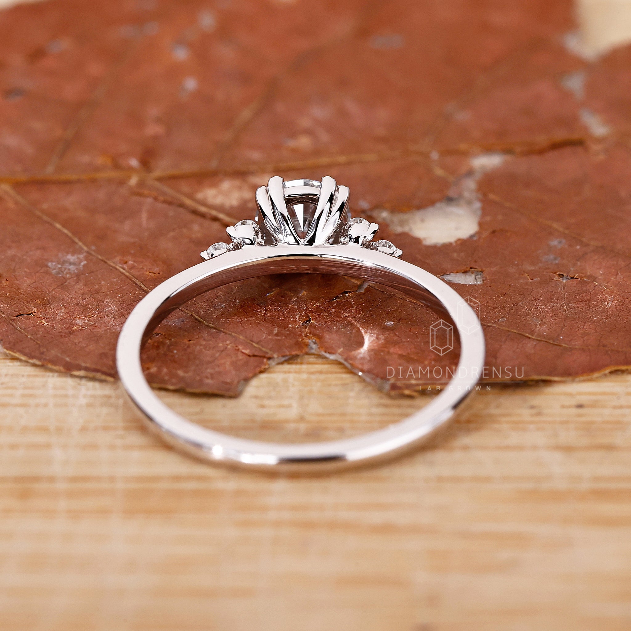 Custom engagement ring with round side diamond and muse setting band.