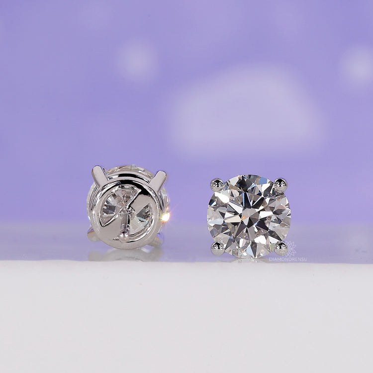 Round diamond stud earrings with handmade gold setting and fine polish.