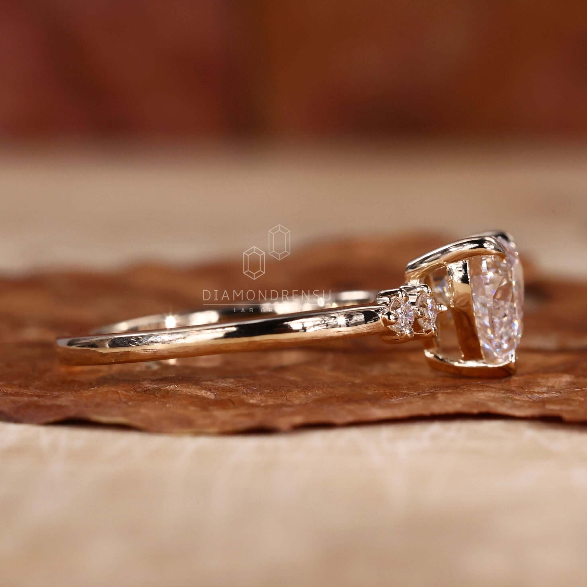 Heart shaped diamond engagement ring with two side stones and lab grown diamond.