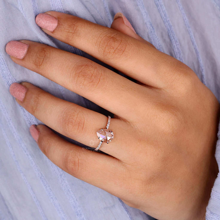 Engagement ring with pave accents and a pear shaped diamond ring centre stone in rose gold.
