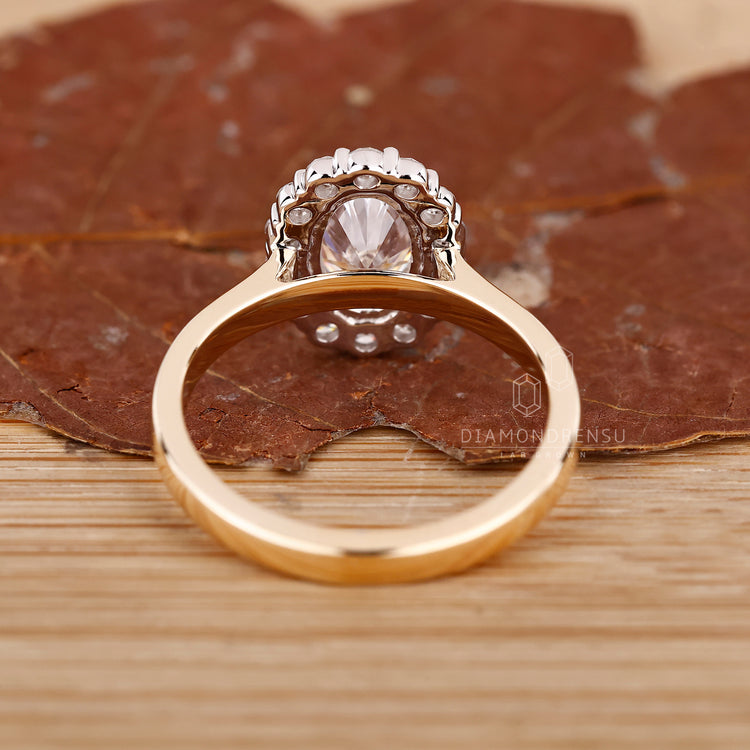 Yellow gold ring with round halo and prong detail.