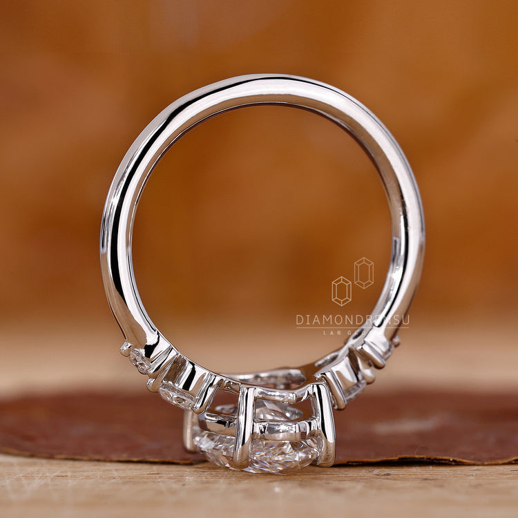 White gold ring with prong setting and round side stones.