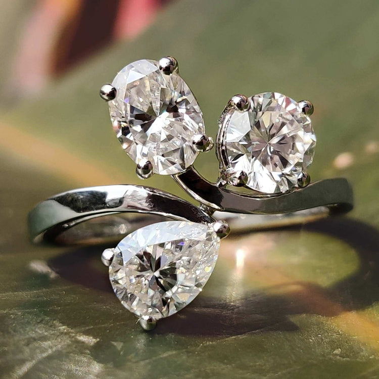3 stone ring with oval, round, and pear cut moissanite.