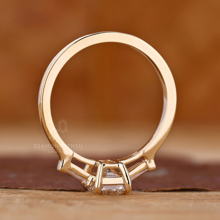 Lab diamond ring with emerald cut and 2 side tapered baguettes for a proposal.