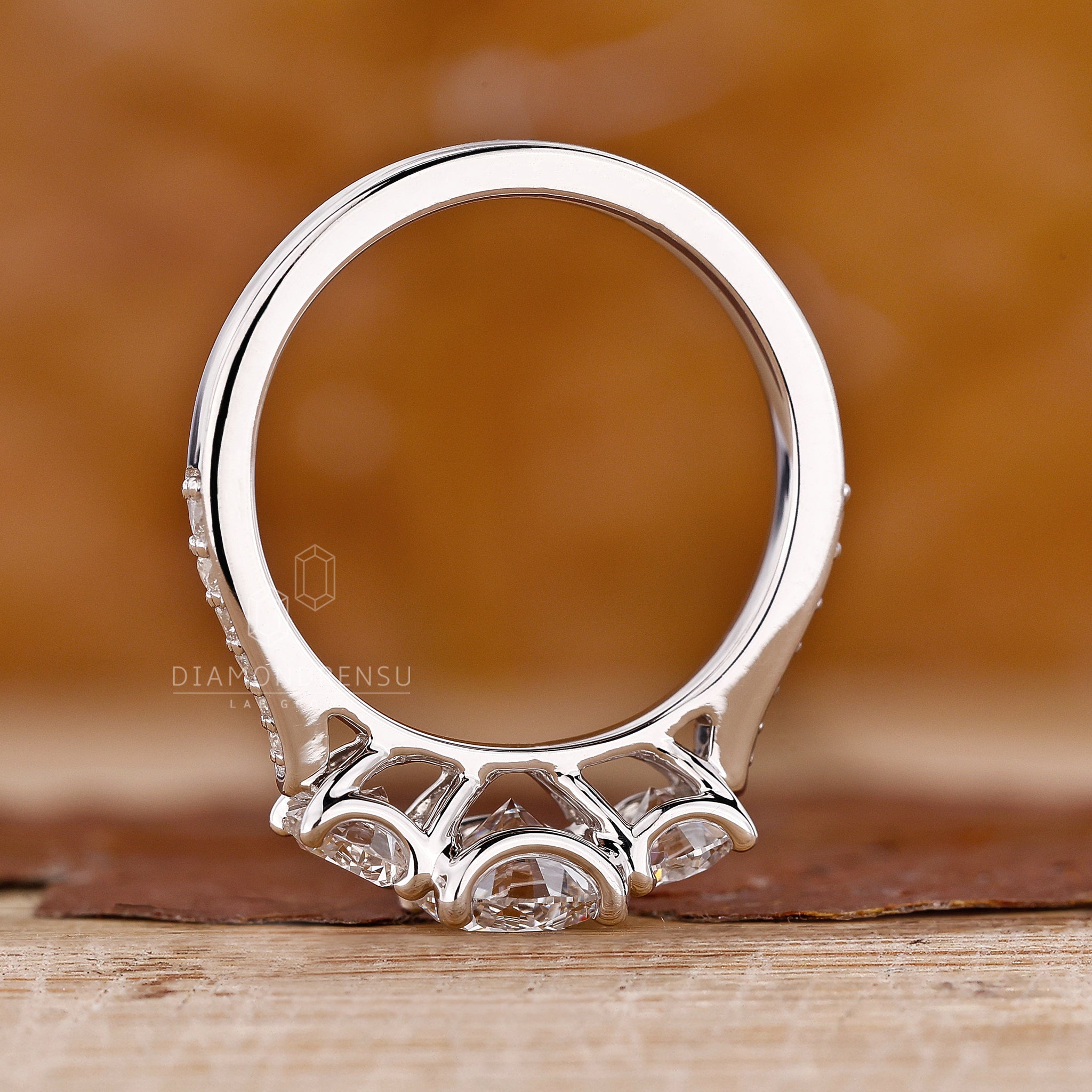 Custom engagement ring with 3 stone design and white gold finish.