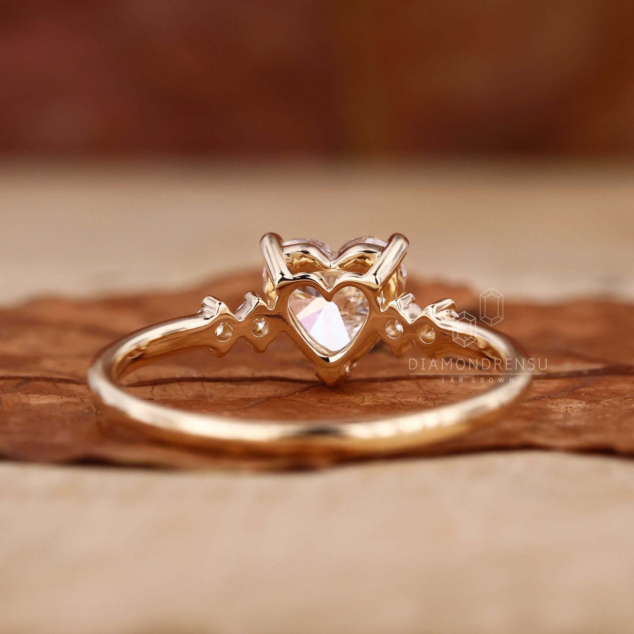 Diamond ring with side stone accents and round cut diamond in a claw prong setting.