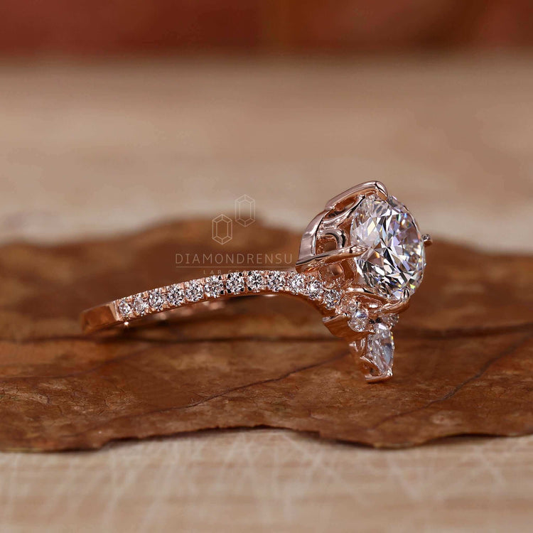 Round diamond ring with a pear diamond centre stone, perfect for a unique engagement style.
