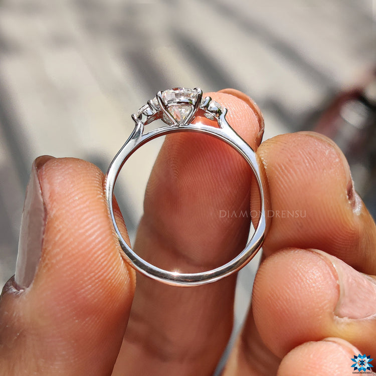 4 claw prong setting secures centre round moissanite engagement stone.