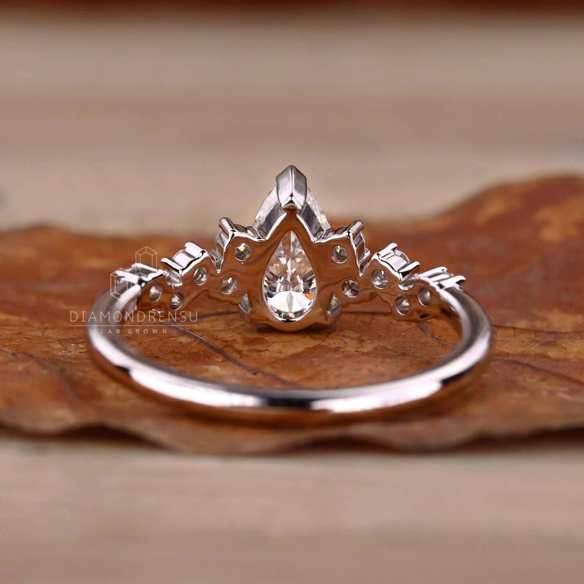 Pear diamond engagement ring in a 4 prong round diamond engagement ring setting, crafted for timeless beauty.