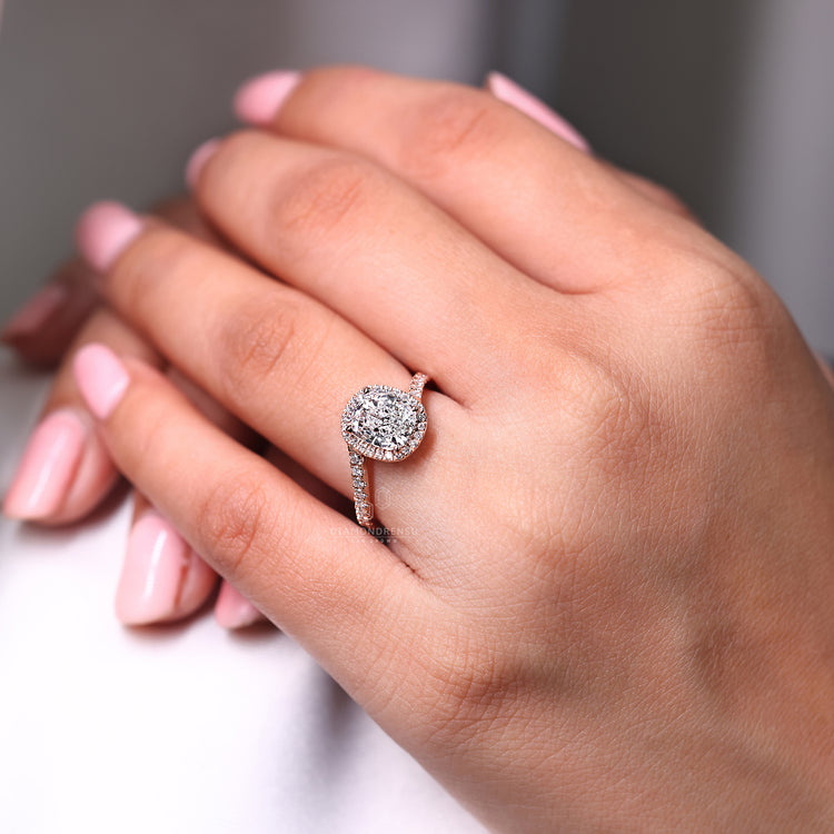 Halo style ring with cushion center in rose gold.