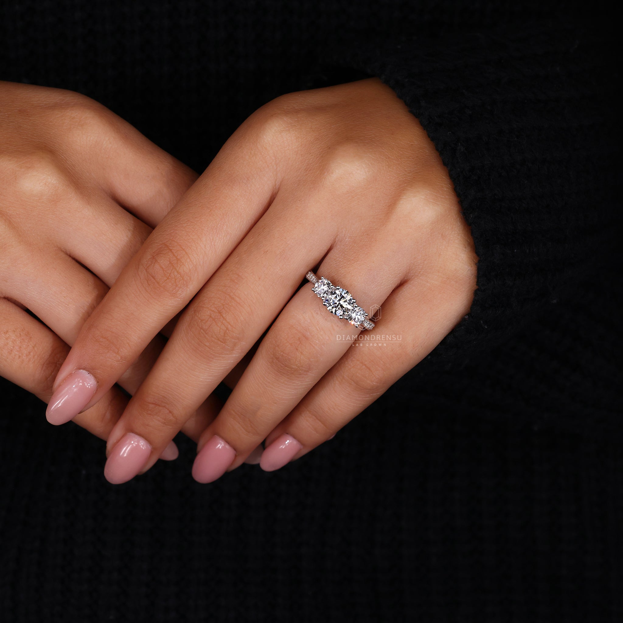 Custom engagement ring with prong set round diamonds and lab diamond.