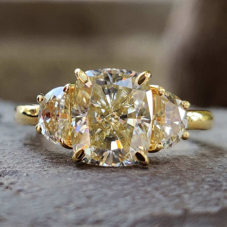 Three stone moissanite ring with cushion cut center.