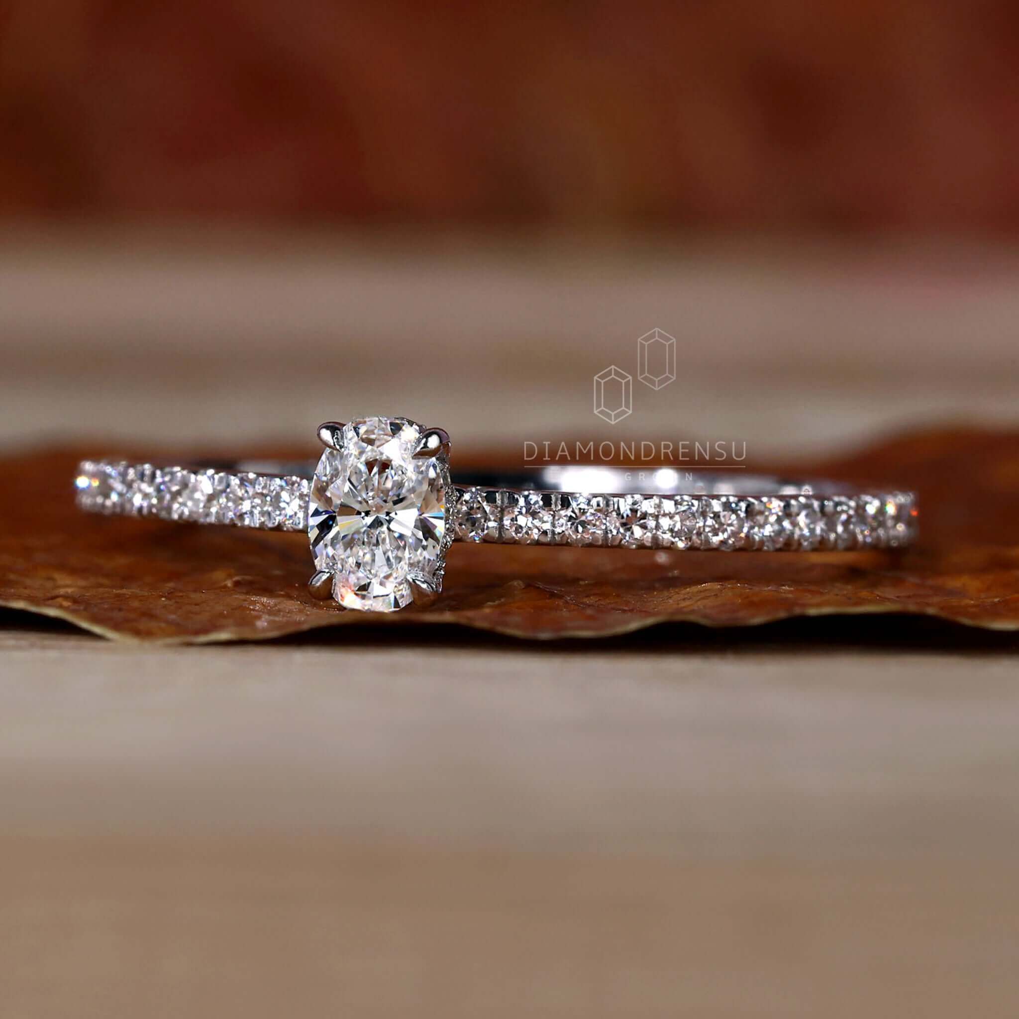Oval diamond engagement ring with a hidden halo and pave diamond accents, perfect for women who love classic styles.