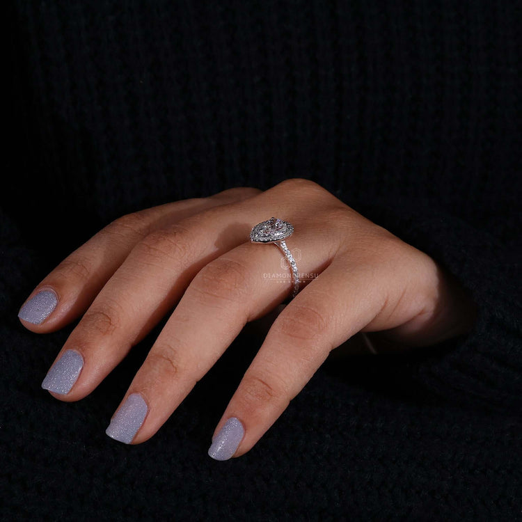 Engagement ring with pave details and a pear diamond in a halo ring ring design.