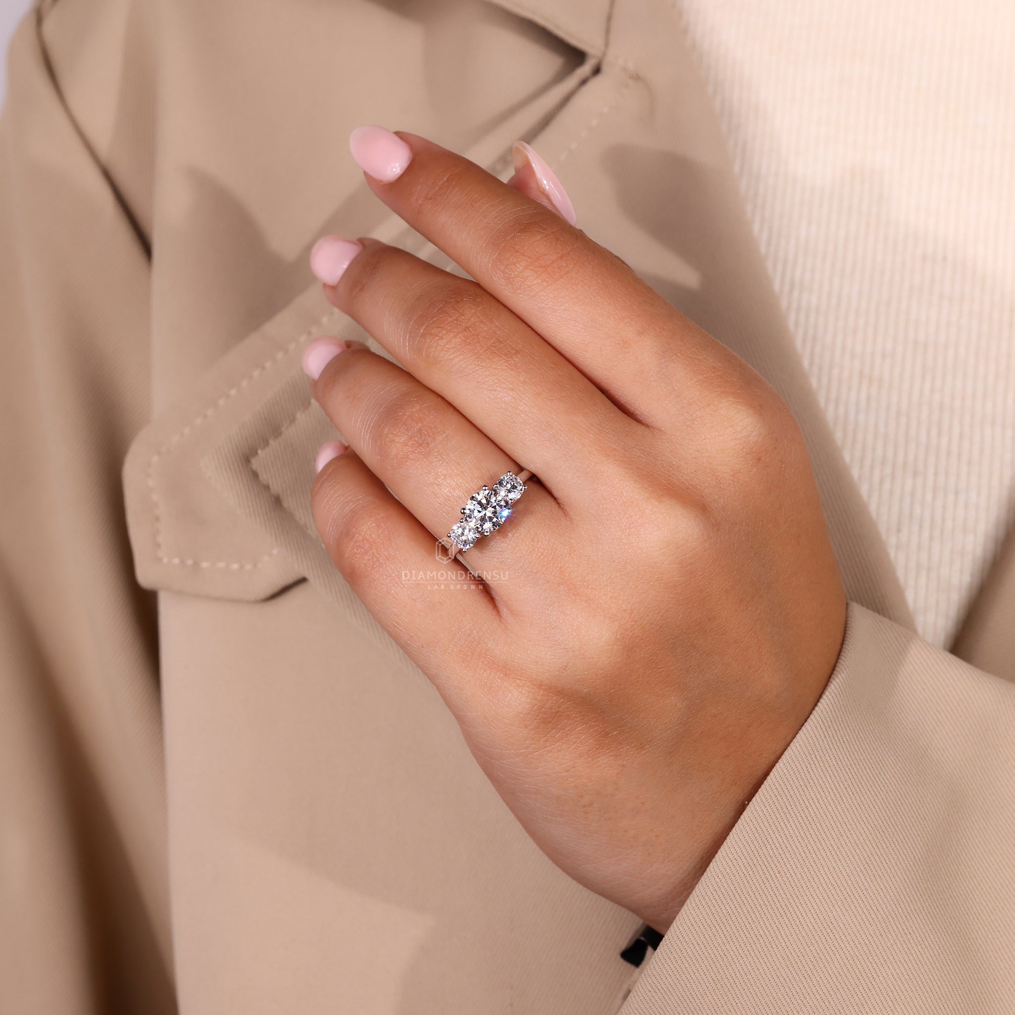 Custom diamond ring with three round stones and white gold band.