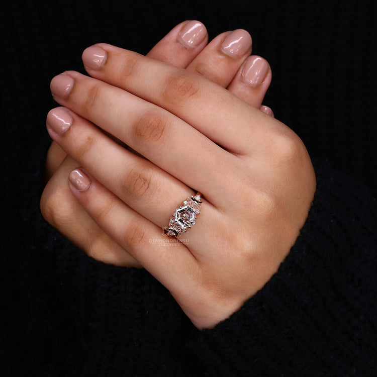 Round diamond side stone held by prong setting.