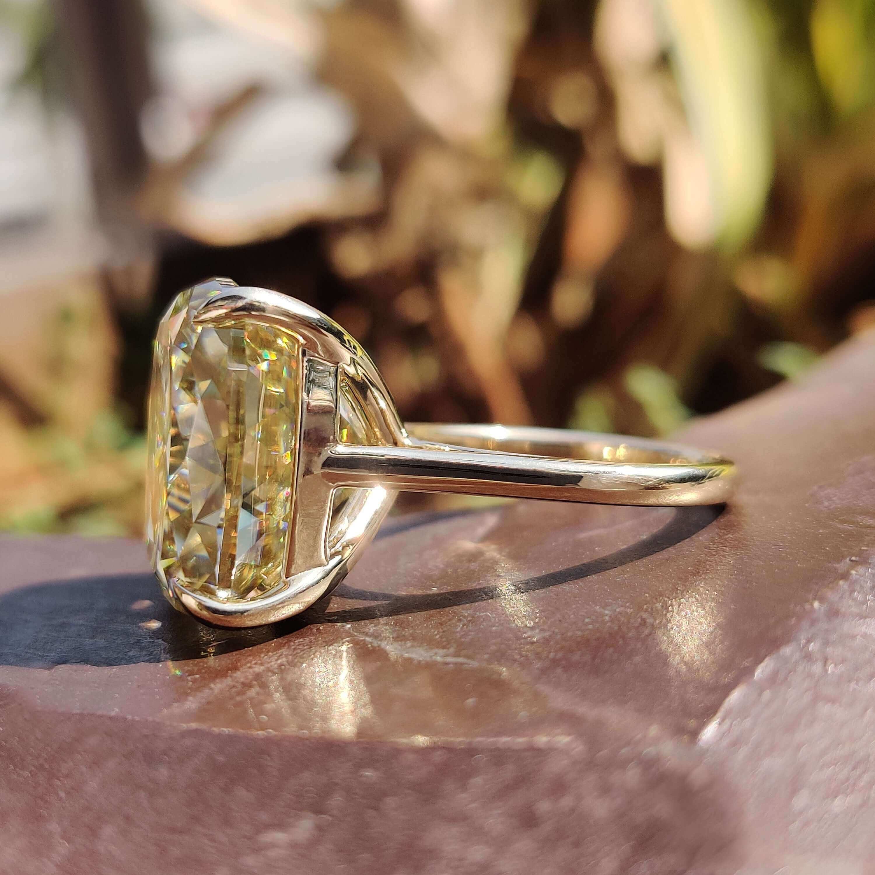 Light yellow cushion moissanite ring in cathedral setting.