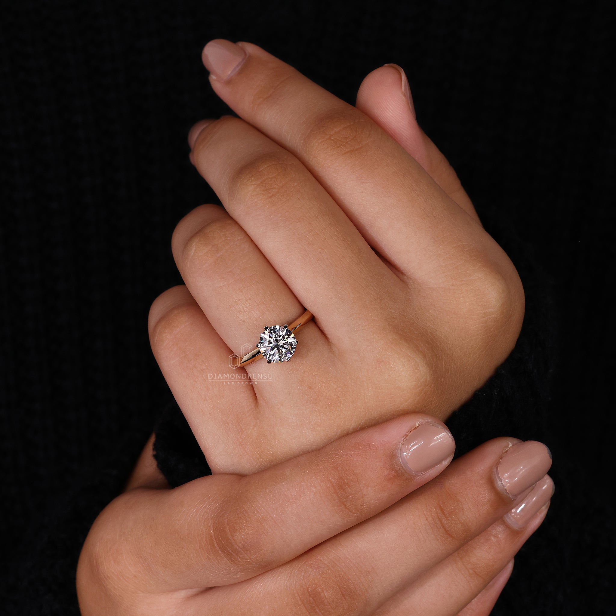 Solitaire diamond ring featuring prong setting and two tone band.