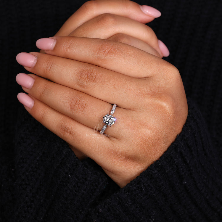 Proposal engagement ring with old mine cushion cut and round diamonds in pave band.