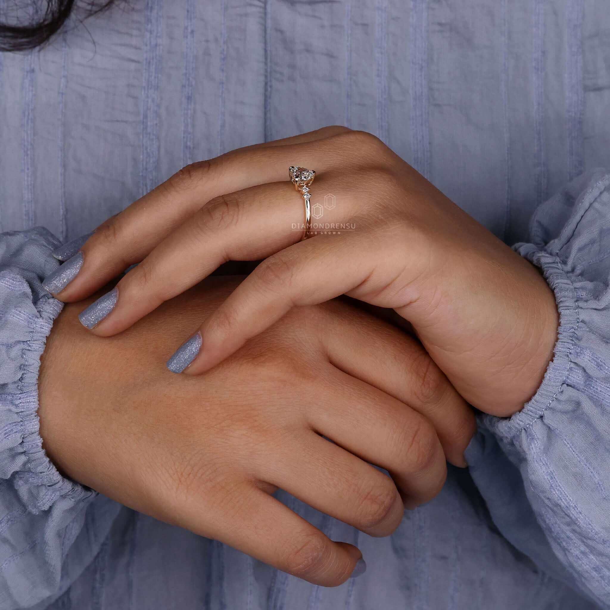 Diamond ring with two side stones paired with a heart shaped diamond centre.