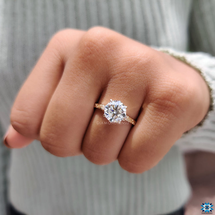 Yellow gold ring with four claw prong setting and side stones.