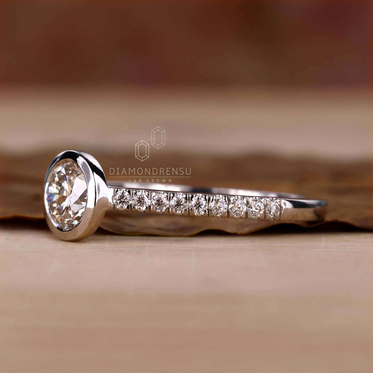 Round diamond engagement ring with a bezel setting and a white gold finish, ideal for women who love classic styles.