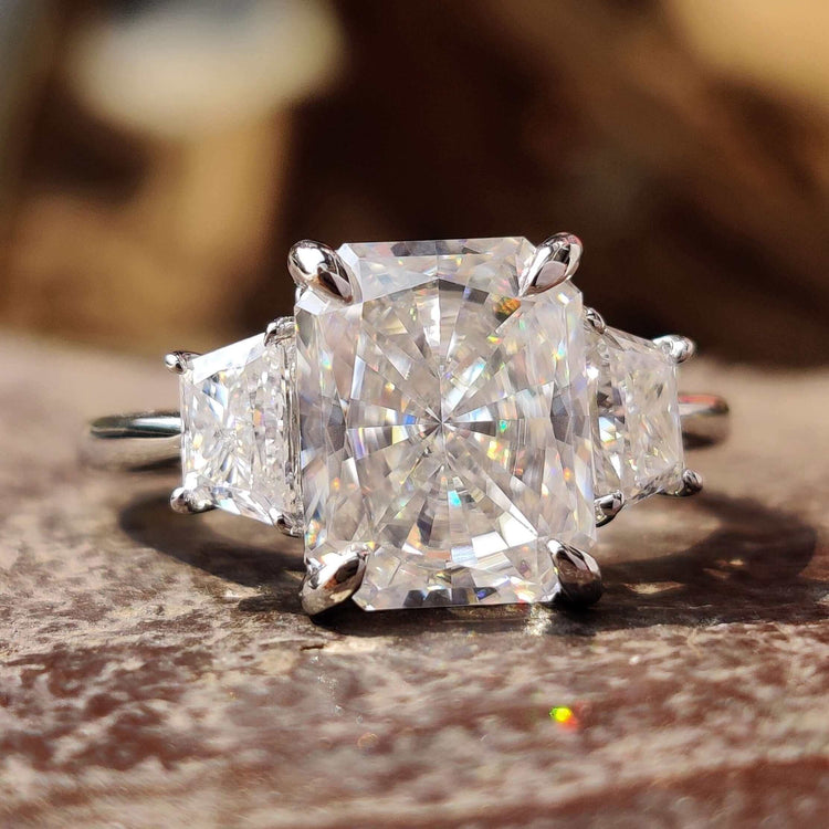 Moissanite 3 stone ring with radiant cut center stone.