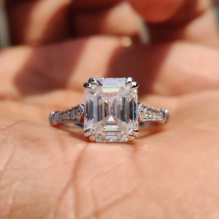 Emerald cut engagement ring with double claw prong and cathedral setting.