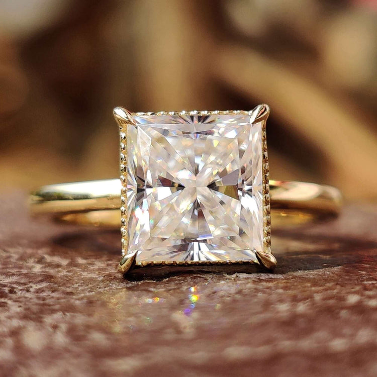 Princess cut engagement ring set in yellow gold with a solitaire design.