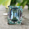 Criss cut ring featuring a cyan blue moissanite in a solitaire setting.
