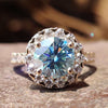 Round moissanite engagement ring with cyan blue center.