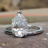 Upside down engagement ring with pear Rensu cut moissanite in a solitaire setting crafted in white gold.