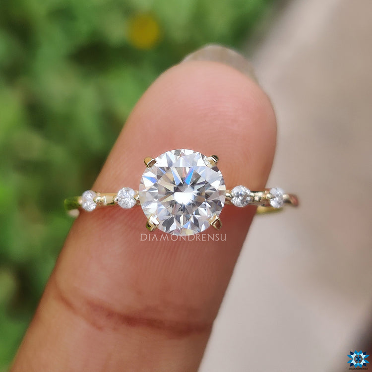 Yellow gold engagement ring with 4 prong setting and brilliant moissanite.