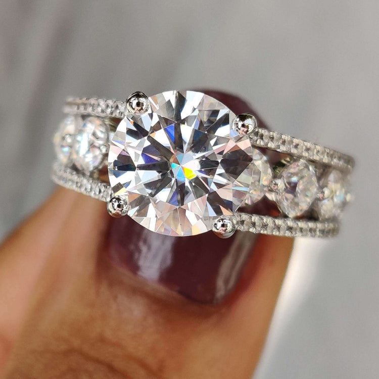 Round cut moissanite engagement ring with side stones.