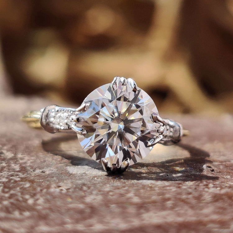 Round cut moissanite engagement ring in two tone gold.