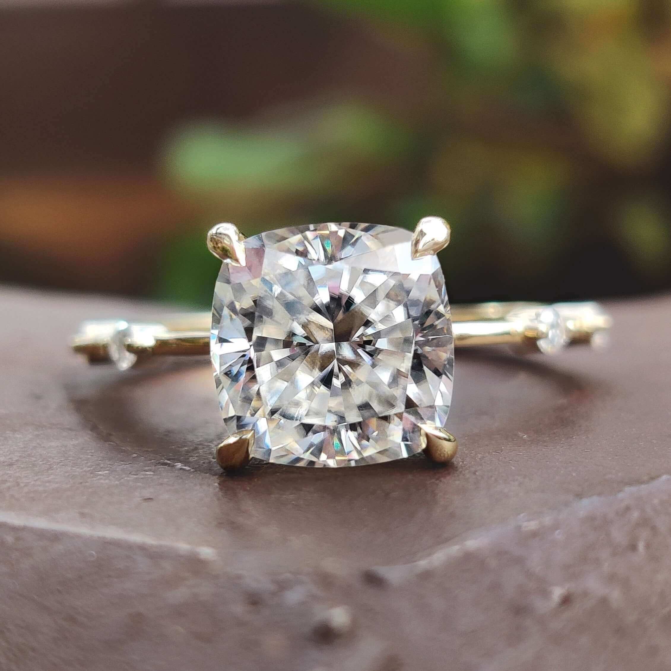 Cushion cut moissanite engagement ring with distance pave design.