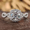 Twisted pave engagement ring with round cut moissanite.