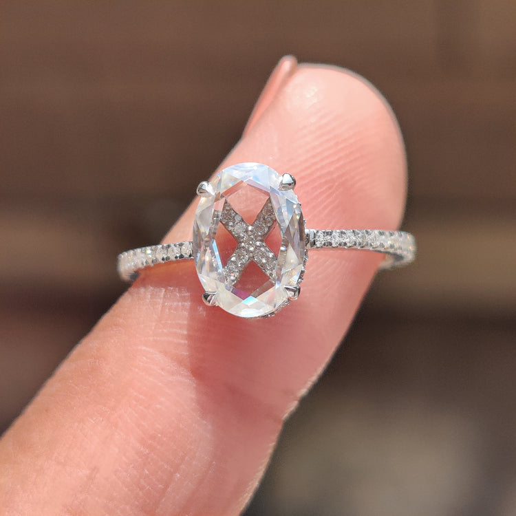Oval rose cut moissanite engagement ring with round hidden halo setting.