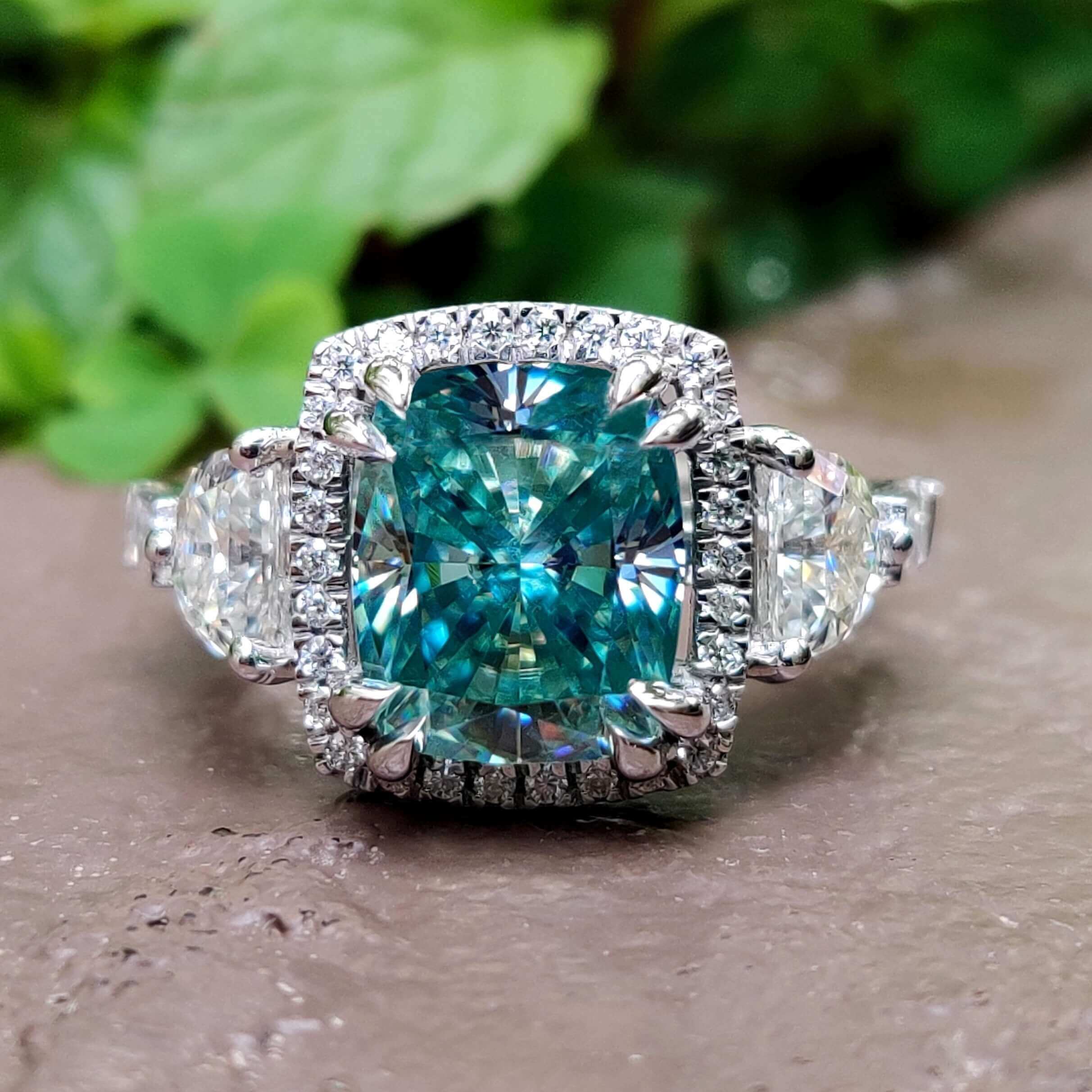 Vintage moissanite engagement ring with cyan blue center stone.