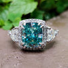 Vintage moissanite engagement ring with cyan blue center stone.
